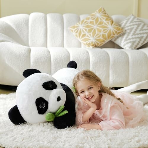 A child smiling with a large panda plush toy on a cozy couch, showcasing its joy and happiness.