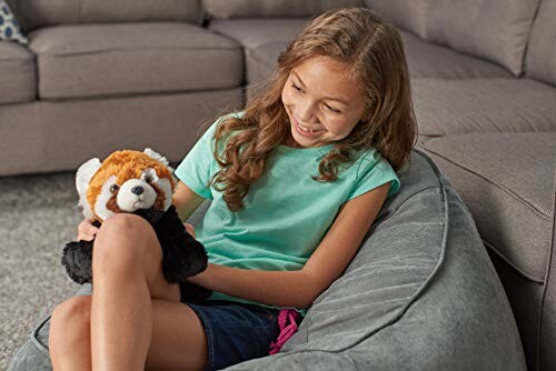 Smiling girl holding a stuffed animal on a couch