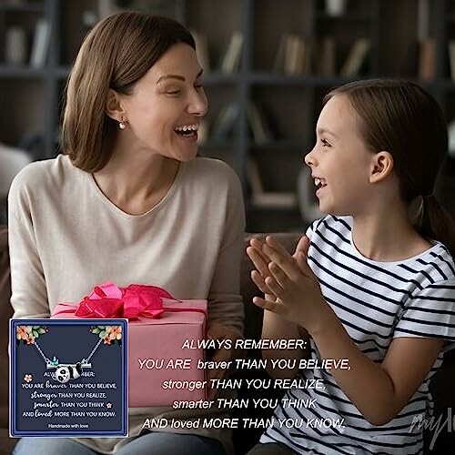 Mother and daughter smiling, holding a gift.