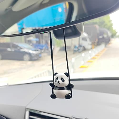 Panda toy hanging from car rearview mirror