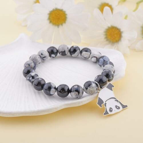 Beaded bracelet with panda charm on shell with daisies.