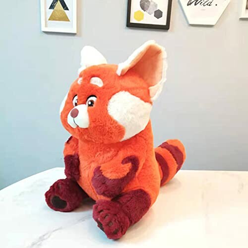 Red panda plush toy on a table.