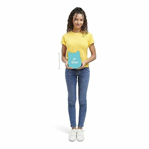 Woman in yellow shirt holding a cat-shaped item