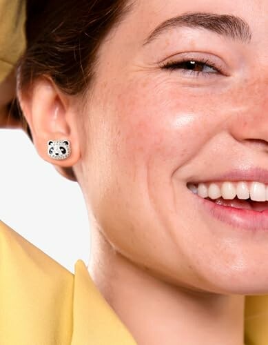 Close-up of woman smiling with panda earring